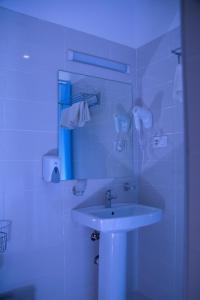 a white bathroom with a sink and a mirror at Hotel & Hostel Escape in Gudauri