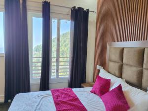 a bedroom with a bed with pink pillows and a window at Sunny Pines Resort in Lansdowne