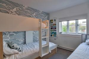 a bedroom with a bunk bed and a book shelf at Finest Retreats - Teylu - Family home for 6 Adults and 3 children in Marhamchurch