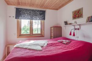 een slaapkamer met een roze bed en een raam bij Stuga i Funäsdalen in Funäsdalen