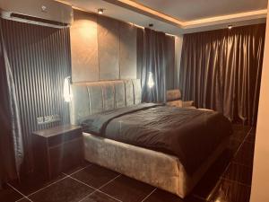 a bedroom with a bed and a chair in it at Skyloft Suite in Lagos