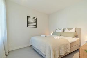 sypialnia z łóżkiem z białą narzutą w obiekcie Modernes Flair: Designer-Apartment in Top-Lage! w mieście Wittlich