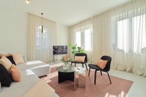 a living room with a white couch and chairs at Modernes Flair: Designer-Apartment in Top-Lage! in Wittlich
