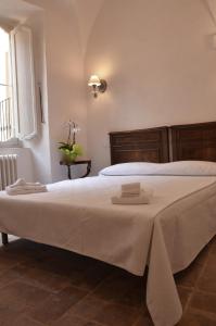 a bedroom with a large bed with white sheets and a window at B&B Antica Biblioteca in Fermo