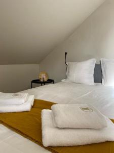 een wit bed met twee handdoeken erop bij bel appartement tout juste rénové 4 personnes in Vierzon