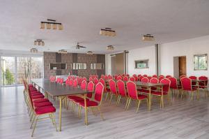 una sala de conferencias con mesa y sillas rojas en B&B Widok en Bielsko-Biala