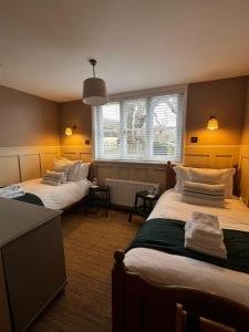 um quarto com três camas e uma janela em Saltmarsh Farmhouse em West Dean