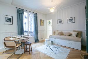 Super cozy Parisian apartment - V90 في باريس: غرفة نوم بسرير وطاولة طعام
