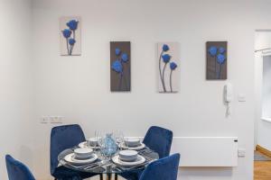 a dining room with a table and blue chairs at Iconic London Apartment in London