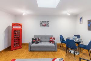 un soggiorno con divano e tavolo con sedie di Iconic London Apartment a Londra