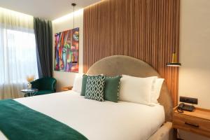 a hotel room with a white bed with pillows at Le M Hôtel in Rabat