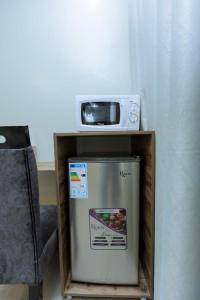 a small refrigerator with a microwave on top of it at Ibi Villa Retreat in Kigali