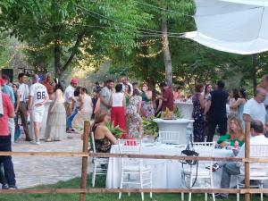 una multitud de personas de pie alrededor de las mesas en una fiesta en H Rural Molino del Rio Argos, en Benablón