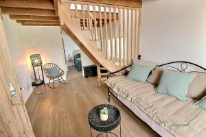 ein Wohnzimmer mit einem Sofa und einer Treppe in der Unterkunft Ker-nath in Saint-Quay-Portrieux