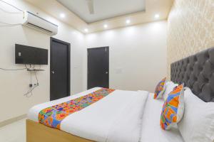 sypialnia z łóżkiem i telewizorem z płaskim ekranem w obiekcie FabHotel US Inn w mieście Waranasi