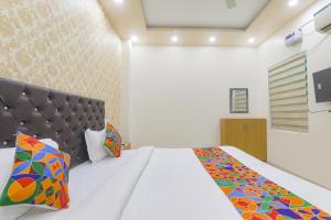 sypialnia z dużym łóżkiem z zagłówkiem w obiekcie FabHotel US Inn w mieście Waranasi