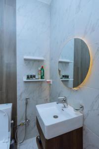La salle de bains est pourvue d'un lavabo, d'un miroir et de toilettes. dans l'établissement Ibi Villa Retreat, à Kigali