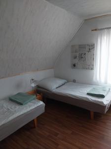 2 Betten in einem Zimmer mit Fenster in der Unterkunft Útulná chaloupka v Krkonoších in Vysoké nad Jizerou