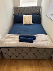 a bed with a blue bedspread and blue pillows on it at One Bed Rylands Street in Warrington