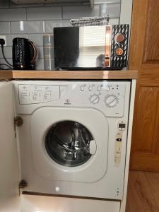 a washing machine with a microwave on top of it at One Bed Rylands Street in Warrington