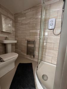 a bathroom with a shower and a toilet and a sink at One Bed Rylands Street in Warrington