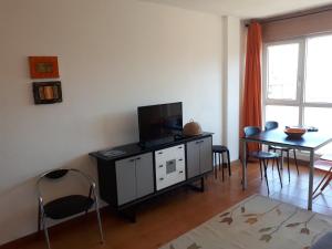 a living room with a television and a table with chairs at Somo Calle Ria Cubas in Somo