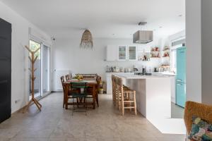 uma cozinha e sala de jantar com mesa e cadeiras em Dream of Mediterranean house, Jacuzzi, BBQ, Délices ensoleillés em Sartrouville