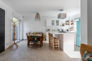 a kitchen and dining room with a table and chairs at Dream of Mediterranean house, Jacuzzi, BBQ, Délices ensoleillés in Sartrouville