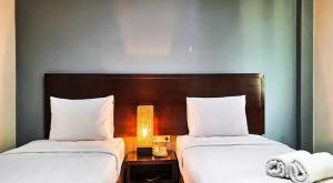 two beds sitting next to each other in a hotel room at N1 Hotel Tanah Abang in Jakarta