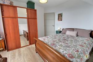 een slaapkamer met een bed en een grote houten kast bij Des faudours in Plérin