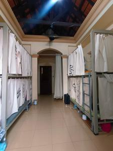 a hallway with white shirts on racks in a room at HOME TEA AN YEN_DORM FOR WOMEN ONLY in Ho Chi Minh City