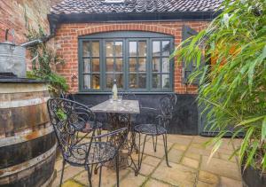 a patio with a table and chairs and a window at Grain Studio in Beccles