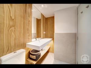baño con lavabo blanco y paredes de madera en COLOMERS de Alma de Nieve, en Naut Aran (Alto Arán)