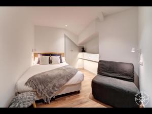 1 dormitorio con 1 cama y 1 silla en COLOMERS de Alma de Nieve, en Naut Aran (Alto Arán)