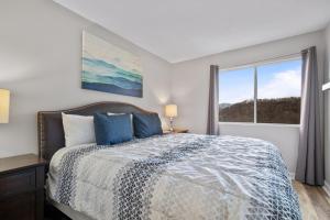 a bedroom with a bed and a large window at Gatlinburg Summit Smoky Mountains View in Gatlinburg