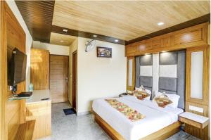 a bedroom with a large bed and a television at Hotel Woods View - Mall Road in Mussoorie