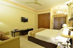 a hotel room with a bed and a television at Pak Continental Hotel in Bahawalpur