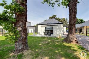 uma casa com duas árvores no quintal em Villa armor azur em Erquy