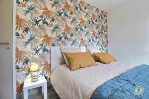 um quarto com uma cama com papel de parede floral em Villa armor azur em Erquy