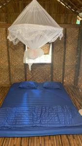 a bed in a small room with a canopy at สวนบุศรา ลานกางเต็นท์วิถีเกษตร in Ban Bok Fai