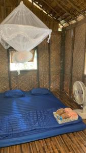 a bed in a room with a mosquito net at สวนบุศรา ลานกางเต็นท์วิถีเกษตร in Ban Bok Fai