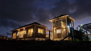 a couple of buildings with the lights on at Charming Cottage in Punta Del Diablo