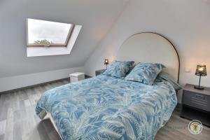 - une chambre avec un lit doté d'une couette bleue et d'une fenêtre dans l'établissement De la porte boissel, à Pléneuf-Val-André