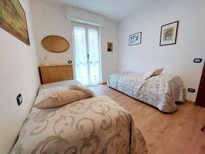 a bedroom with two beds and a window at Sunset House Perledo in Perledo