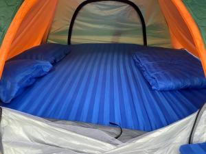 - un lit dans une tente avec 2 oreillers dans l'établissement สวนบุศรา ลานกางเต็นท์วิถีเกษตร, à Ban Bok Fai
