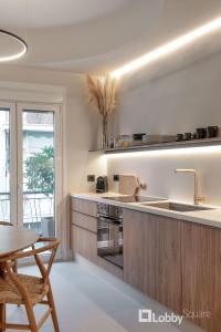 cocina con fregadero y encimera con mesa en Muse Apartment by LobbySquare, en Atenas