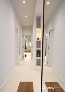 un pasillo de una casa con paredes blancas y espejo en Muse Apartment by LobbySquare, en Atenas