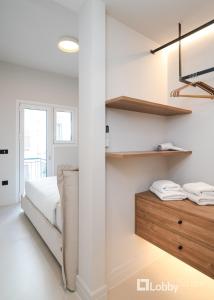 a bedroom with white walls and a bed and shelves at Muse Apartment by LobbySquare in Athens