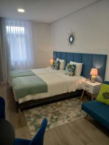 sypialnia z dużym łóżkiem z niebieskim zagłówkiem w obiekcie Garden House Fundão - Estúdio 101 com vista jardim w mieście Fundão