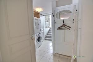 a white laundry room with a washer and dryer at Vers le port in Créhen